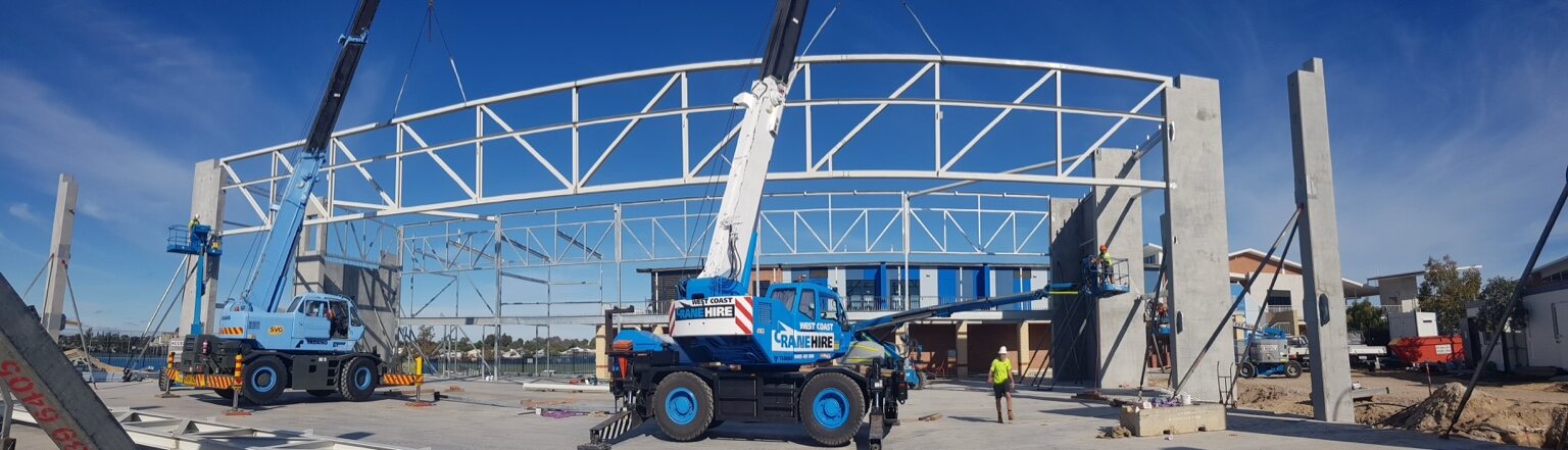 West Coast Crane Hire and another city crane installing steel roof trusses